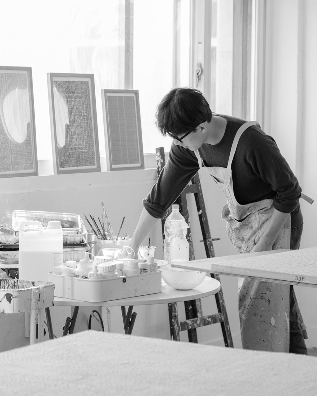 Woo Byoung Yun at work in his studio in Goyang, with paintings leaning against the wall